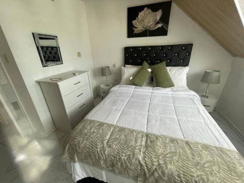 SalemReal Luxe Getaway-Club Caribbean的卧室配有带绿色枕头的大型白色床