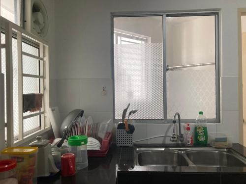 普特拉贾亚ABSYAR HOMESTAY SELASIH的厨房设有水槽和窗户。