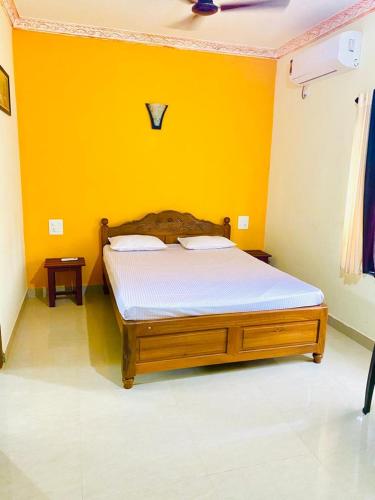莫尔吉姆Vyana villa rooms的黄色墙的房间里一张床位