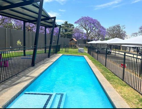 约翰内斯堡Green with Envy-Luxury Apartment- No Loadshedding的一个带围栏的院子内的游泳池