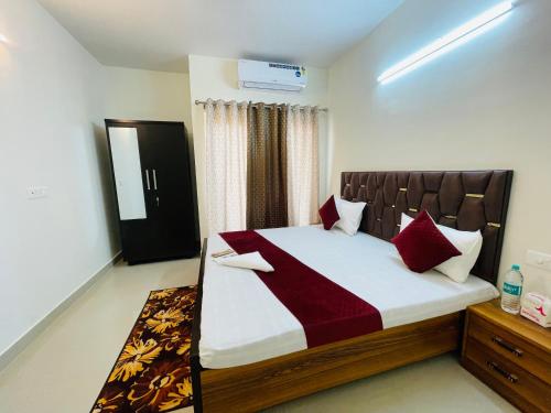 勒克瑙ALanKrita Homes的一间卧室配有一张带红色枕头的大床