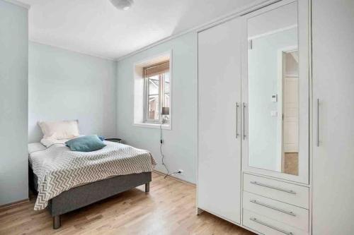 特罗姆瑟Warm and lovely apartment with free parking的一间卧室配有床和白色的大橱柜