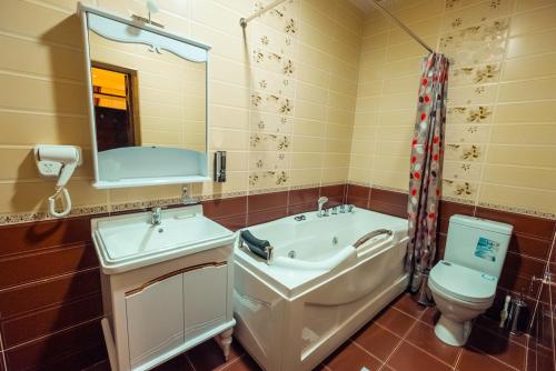 撒马尔罕Meros Boutique Hotel的一间带水槽、卫生间和镜子的浴室