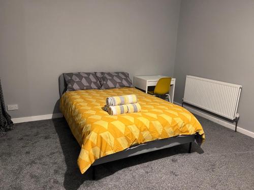 CanleyModern Room Close to Warwick University的一间卧室配有一张黄色棉被的床