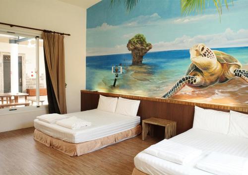 小琉球岛小杉丘民宿的一间设有两张床的房间和一幅恐龙画