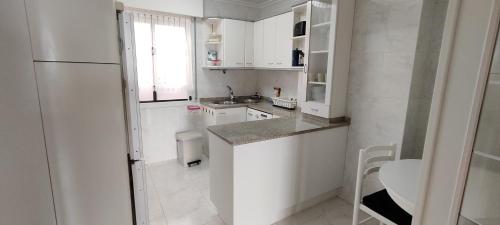 蒙达卡Mundaka Izaro Eye的厨房配有白色橱柜和白色冰箱。