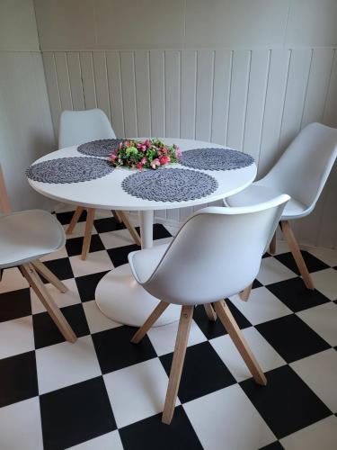 艾内科斯基Hietaman Vierastalo Marilyn的一张桌子,上面摆放着白色的椅子和插花