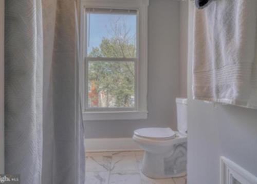 巴尔的摩Budget Bed Room near Downtown Inner Harbor w Free Parking的白色的浴室设有卫生间和窗户。