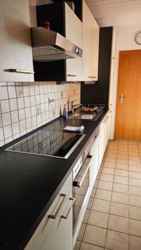 斯高哈赫Zweite Heimat Bamberg的厨房配有白色橱柜和黑色台面