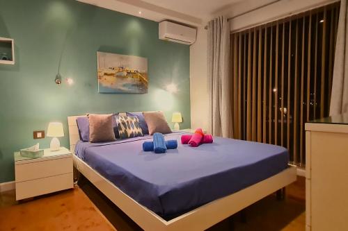 马尔萨斯卡拉Unobstructred seaviews, 2BR, Kingbeds, Fully ACd的一间卧室配有一张大床,提供紫色床单和蓝色枕头