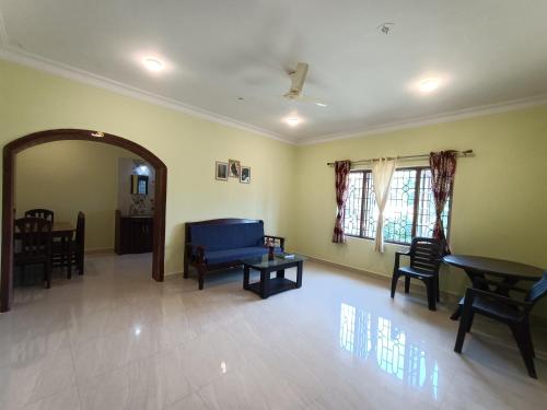 阿姆波尔Pappa's Guest House的客厅配有蓝色的沙发和椅子