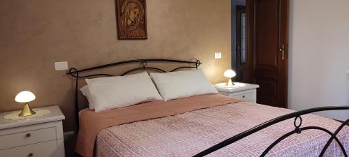 罗马Tra le antiche mura e Garbatella的一间卧室配有一张带2个床头柜和2盏灯的床。