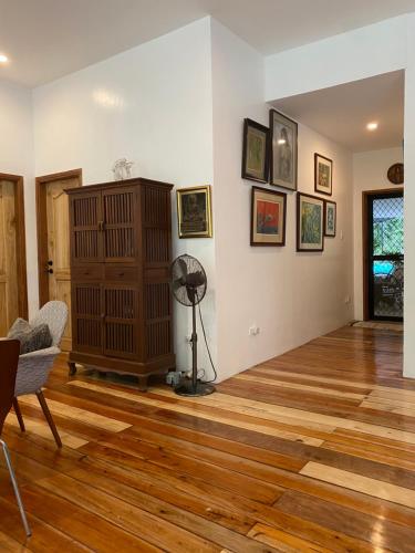 BacnotanBalai Benedicere Bed & Breakfast的客厅铺有木地板,配有风扇。