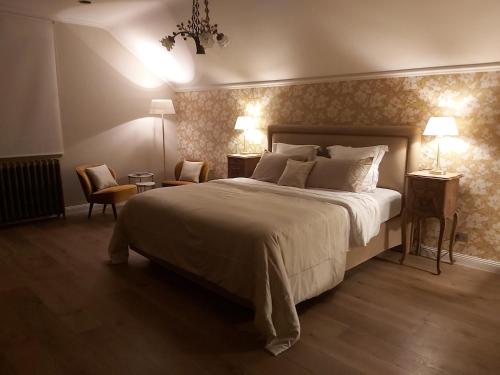 马斯梅赫伦B&B Asmara的一间卧室配有一张大床和两张桌子及椅子