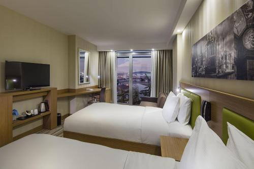伊斯坦布尔希尔顿伊斯坦布尔阿塔科伊汉普顿酒店的酒店客房设有两张床和电视。