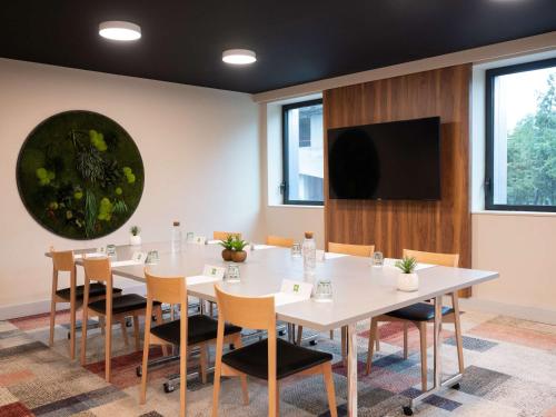 巴黎ibis Styles Paris Meteor Avenue d'Italie的一间会议室,配有白色的桌椅和平面电视