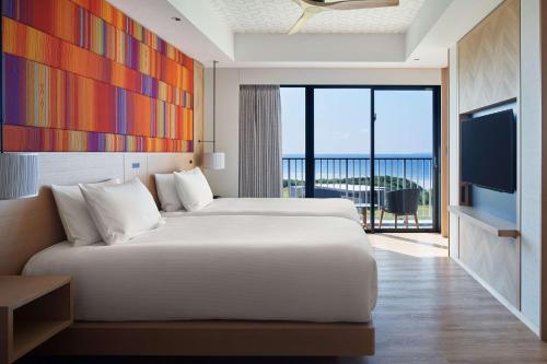 本部Hilton Club The Beach Resort Sesoko的酒店客房,配有床和电视