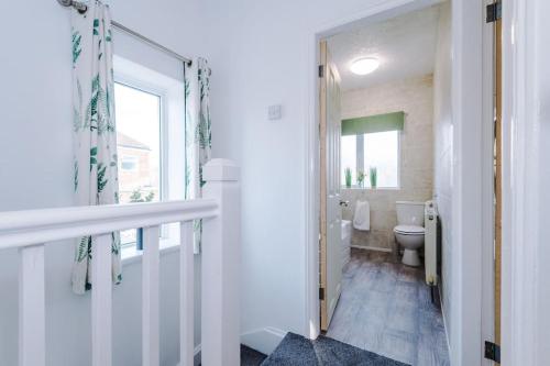 约克Cosy Three-Bedroom House Near City Centre with Free Parking的白色的浴室设有卫生间和窗户。