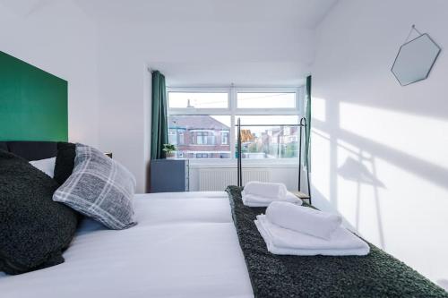 约克Cosy Three-Bedroom House Near City Centre with Free Parking的一间卧室配有一张床,上面有两条毛巾