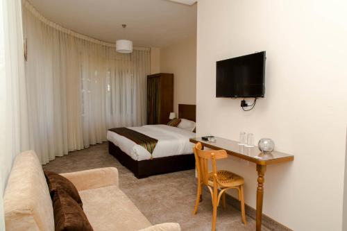 安曼安曼安蒂卡酒店的酒店客房配有一张床和一张沙发桌子
