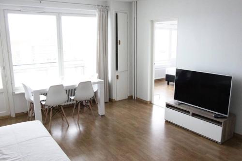 图尔库Norden Homes City Centre 2-Bedroom Apartment + Free Parking的客厅配有电视和桌椅