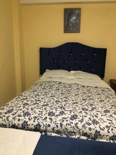 卡哈马卡El Seminario Hospedaje的卧室内的一张床铺,配有蓝色和白色的床罩