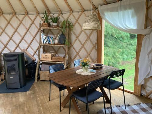 奥赫里姆Aughavannagh Yurt Glamping的蒙古包内的一张木桌和椅子