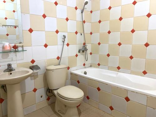 Quang TriKHÁCH SẠN PHỤNG HOÀNG的浴室配有卫生间、浴缸和水槽。