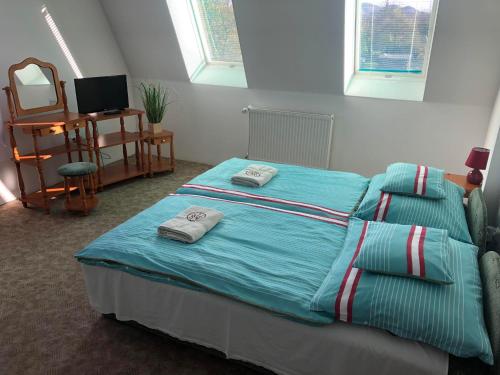 FüzérradványKorona Panzió的一间卧室配有一张床,上面有两条毛巾