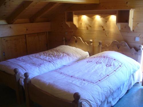 大博尔南Chalet Le Grand-Bornand, 7 pièces, 13 personnes - FR-1-467-31的木制客房内的一间卧室,配有一张床