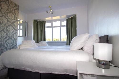 格兰瑟姆Fully renovated spacious home, Sleeps 5,的卧室配有一张大白色床和窗户