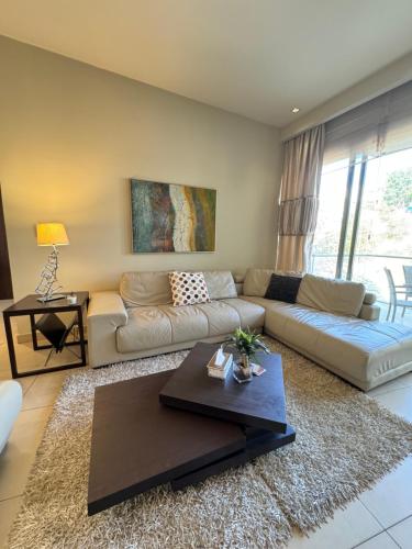 安曼Abdoun Falls Luxury Apartment的客厅配有沙发和桌子