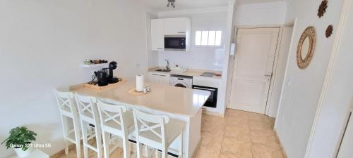蒂亚斯Bella Vista 414-Ocean Lanzamar- Puerto Del Carmen的白色的厨房设有柜台和厨房岛