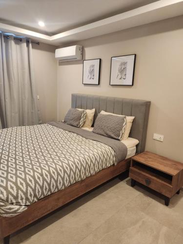 Sere KundaCosta Vista-1 Bedroom apartment#410 kololi Sands的一间卧室配有一张床和一张木桌