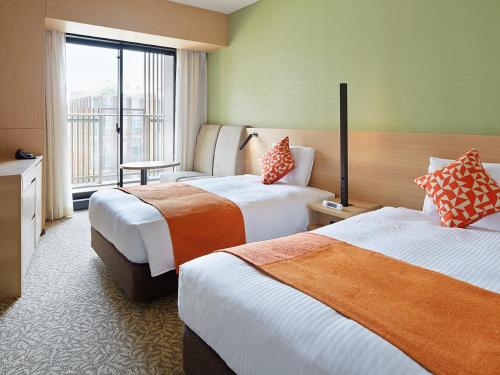 柏市三井花园饭店柏叶 / 千叶的酒店客房设有两张床和窗户。