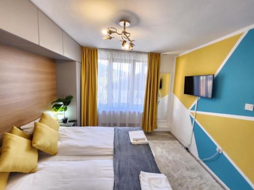 戈韦达尔齐Bulgarane House的酒店客房的一张大床拥有黄色和蓝色的墙壁