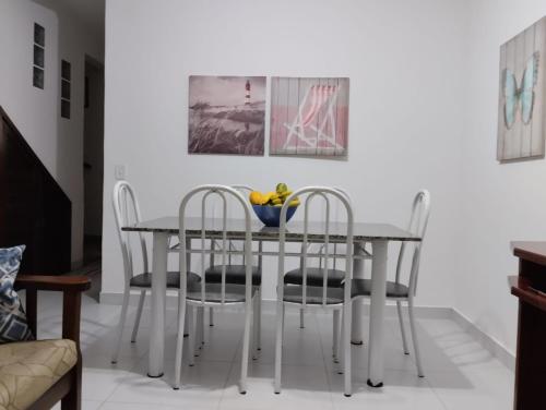 伯迪亚哥Recanto Vista Mar的餐桌、椅子和一碗水果