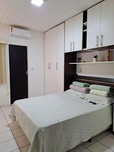 萨尔瓦多Vilage Taipan 02 - Praia Stella Maris的一间卧室配有一张带白色橱柜的大床