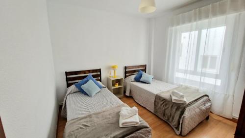 阿尔巴塞特Apartamento ZONA的一间卧室设有两张床和窗户。