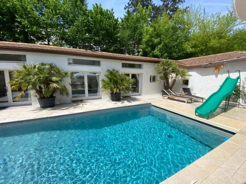 日内瓦Residence Mont-Blanc Poolhouse的房屋前带滑梯的游泳池