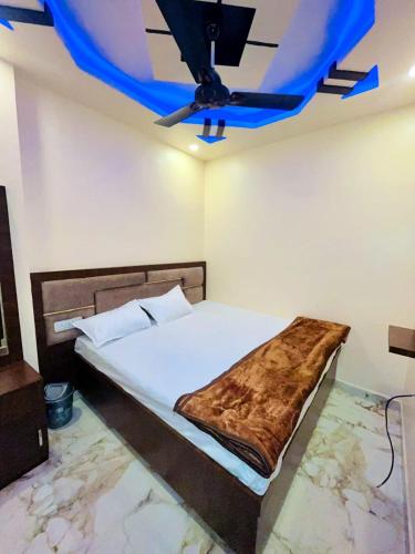 乌贾因KRISHNA PALACE的一间卧室配有一张蓝色天花板的床