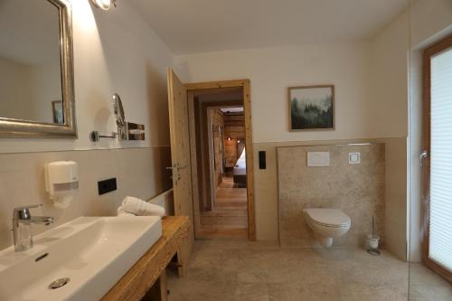 巴德小基希海姆卢娜其尔豪夫旅馆加公寓的一间带水槽、卫生间和镜子的浴室
