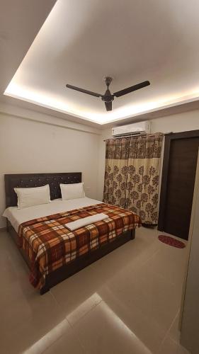 加济阿巴德Gokul 3BHK Service Apartment Bharat City Ghaziabad near Hindon Airport的一间卧室配有一张床和吊扇