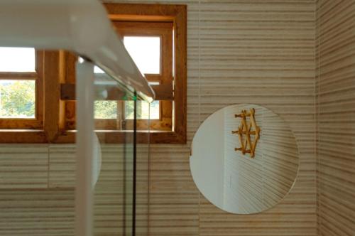 帕尔梅拉斯Blue House Vale do Capão的浴室墙上的圆镜子