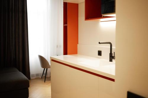 久姆里BARBAR APART HOTEL的厨房配有白色水槽和橙色墙壁