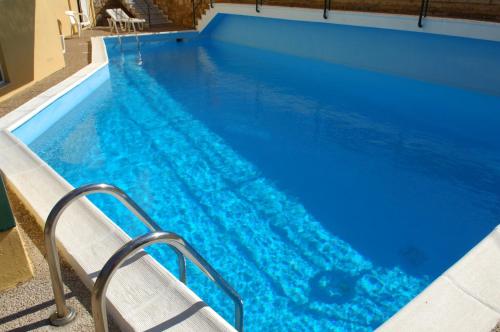 Agia ErmioniSunrise Hotel的蓝色海水游泳池,里面设有楼梯