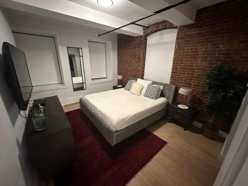 纽约Large 3 bedroom in Flatiron的一间卧室设有一张床和砖墙