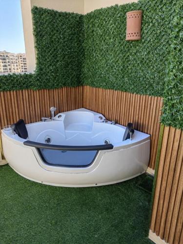 赫尔格达Cordoba suites Penthouse with private open air Jacuzzi的绿色墙壁前的白色浴缸