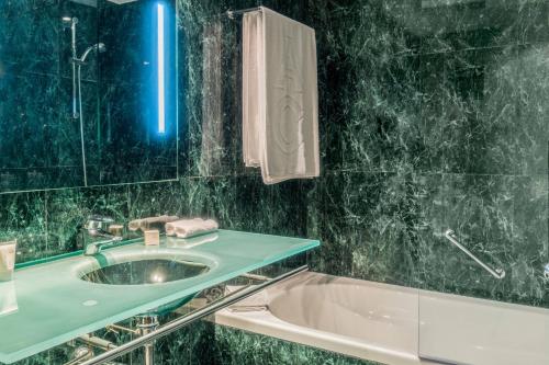 瓦伦西亚巴伦西亚AC万豪酒店的浴室配有盥洗盆和浴缸。