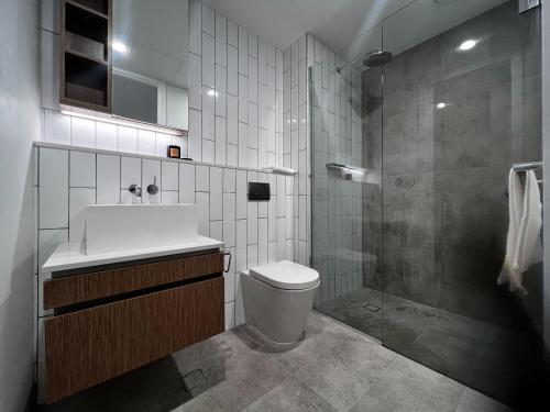 墨尔本Samma Flagstaff Luxury Apartments的一间带水槽、卫生间和淋浴的浴室